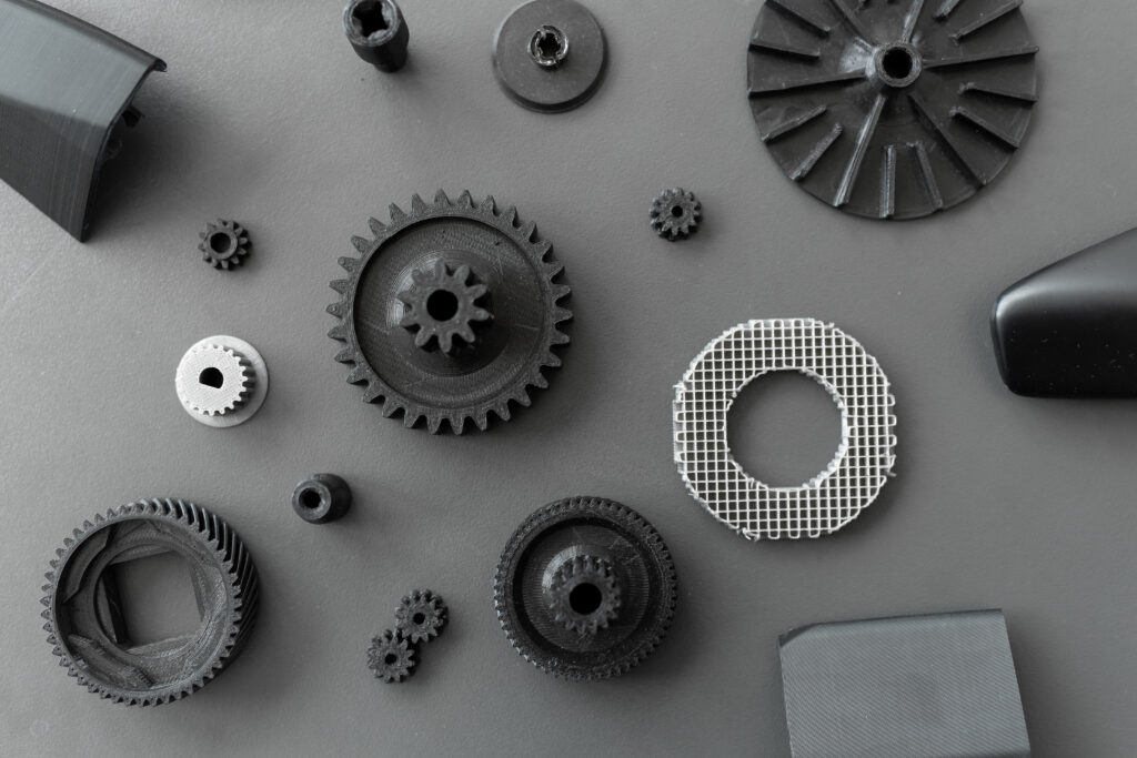 Professionell 3D-gedruckte technische Teile aus PETG: Zahnräder, ein Lüfterrad und ein Gitterzylinder für Rapid Prototyping Projekte. Diese Bauteile können Kunden bei printmy3d.de 3D drucken lassen.