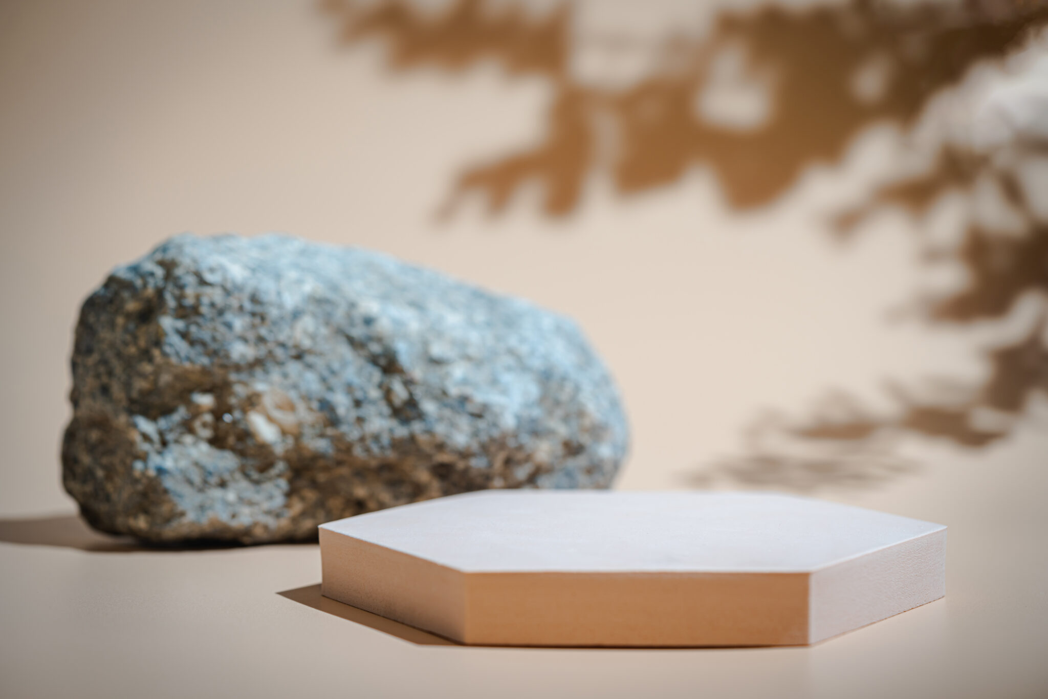 Minimalistisches Produkt-Setting für PLA+ 3D-Drucke: Ein stabiles Podium neben einem Naturstein, das die hohe Zähigkeit und Belastbarkeit von PLA-Plus Filament für technische Prototypen symbolisiert.